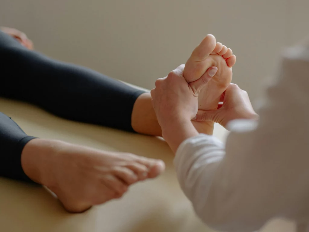 Massage des pieds d'une femme allongée, réflexologie plantaire